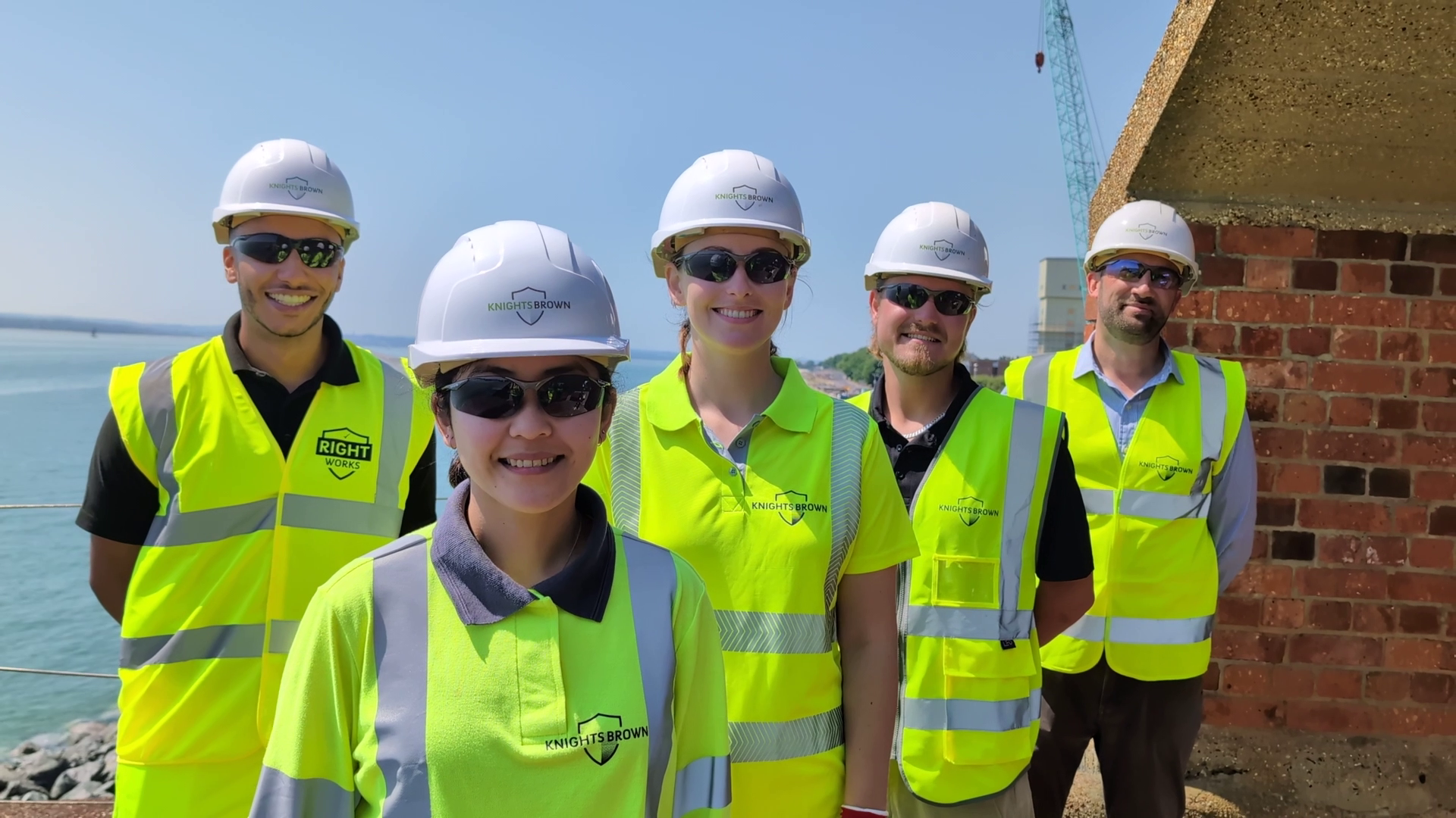 group of people stood together wearing hard hats and high vis vests